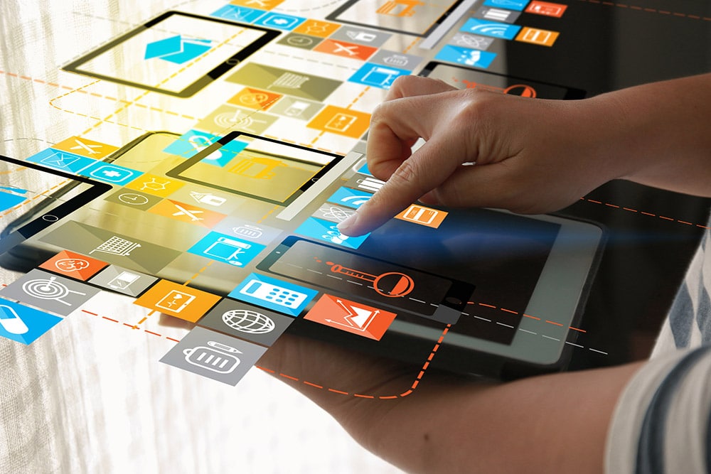 Jemand berührt ein Tablet über das eine digitale Ebene schwebt mit unterschiedlichen Grafiken zu digitalem und print Marketing