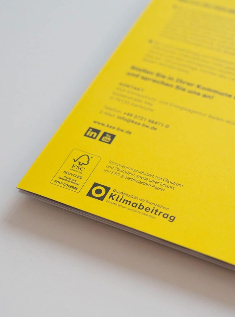 Eine gelbe Broschüre mit Umweltlogos.