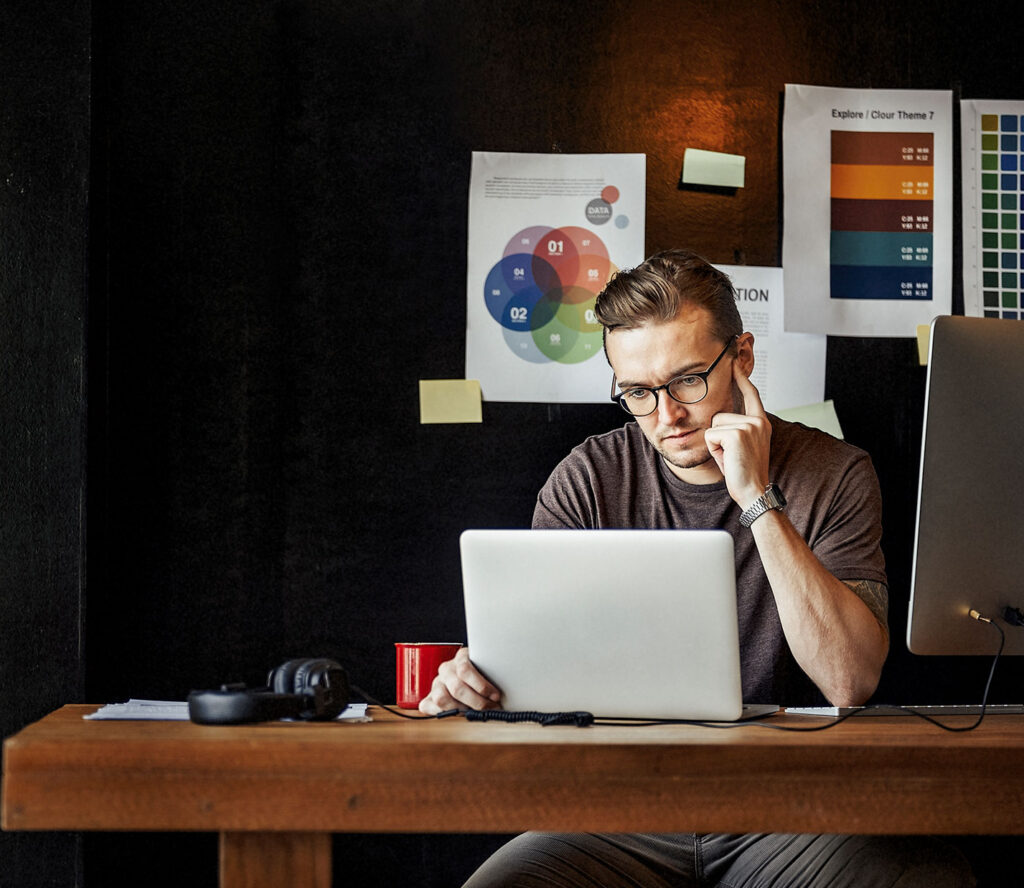 Mann sitzt vor Notebook und arbeitet