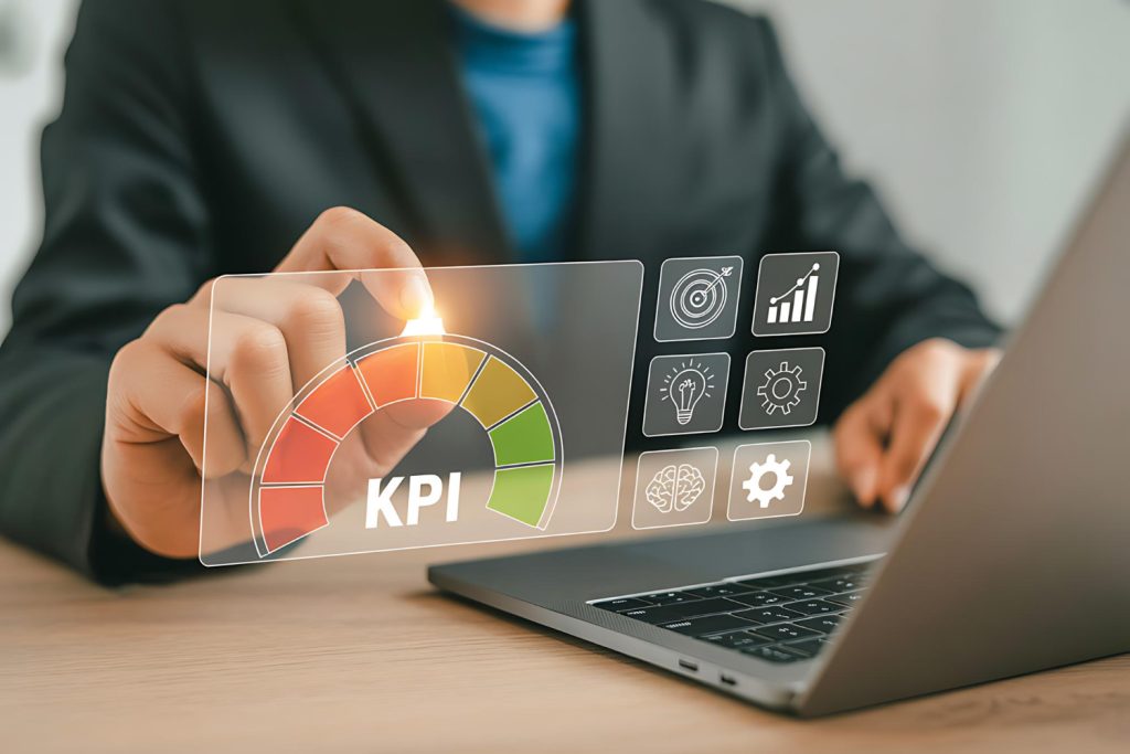 Person bedient am Laptop eine digitale KPI Anzeige mit Diagrammen und Symbolen