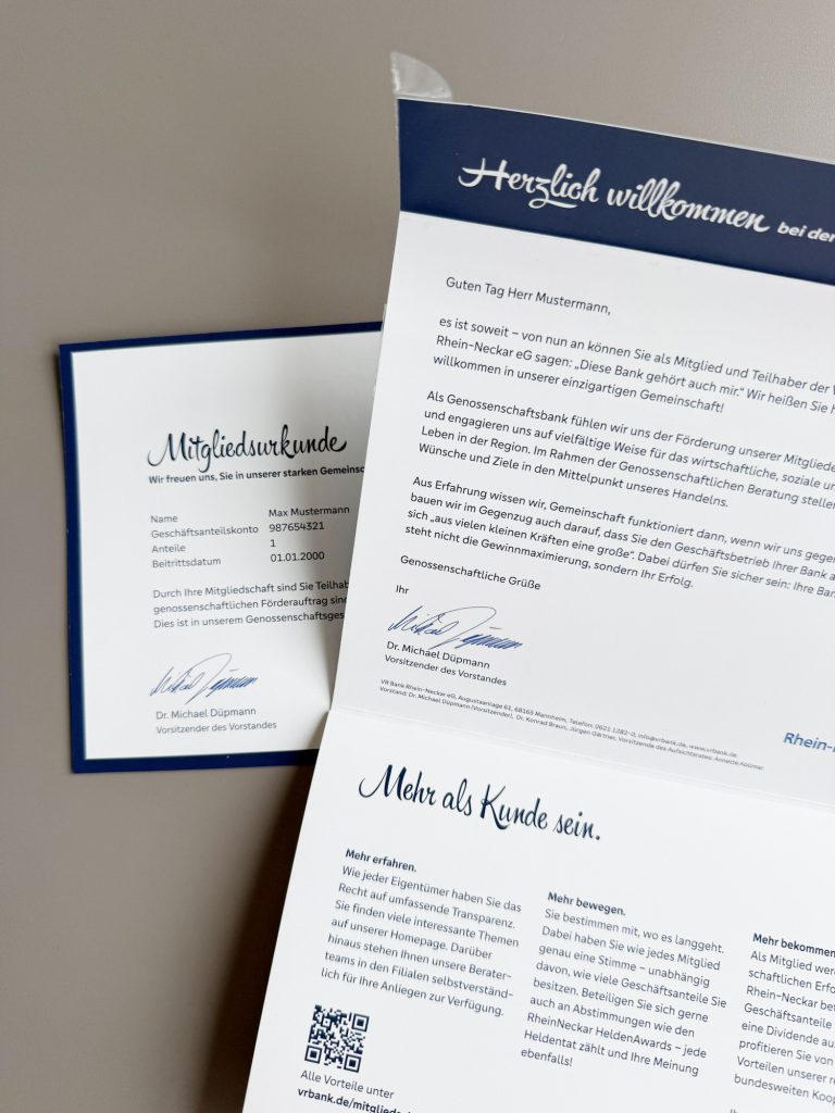 Geöffneter Selfmailer mit Willkommensschreiben und Mitgliedsurkunde in blau weißem Design