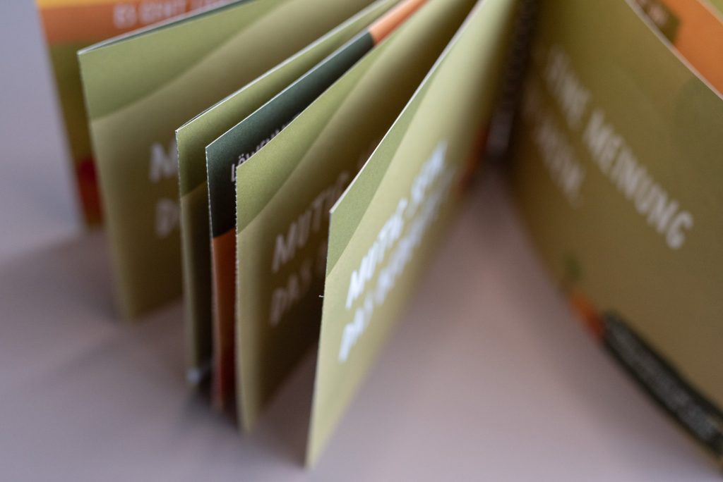 Individuelles Mitmachbuch mit Spiralbindung auf FSC-Recyclingpapier und integrierten Perforationen für interaktive Inhalte.